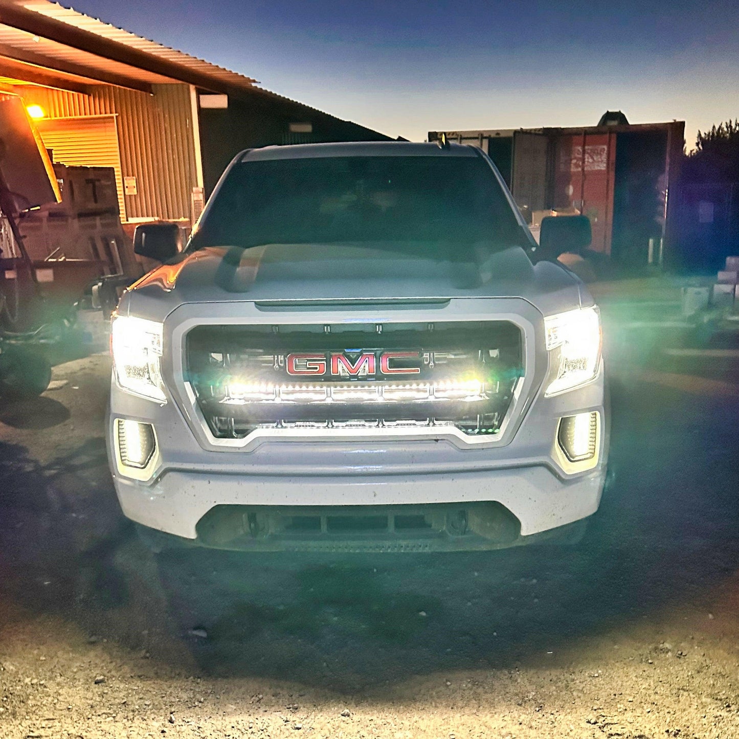 GMC truck with LED Light Bars illuminated headlights in a dimly lit area