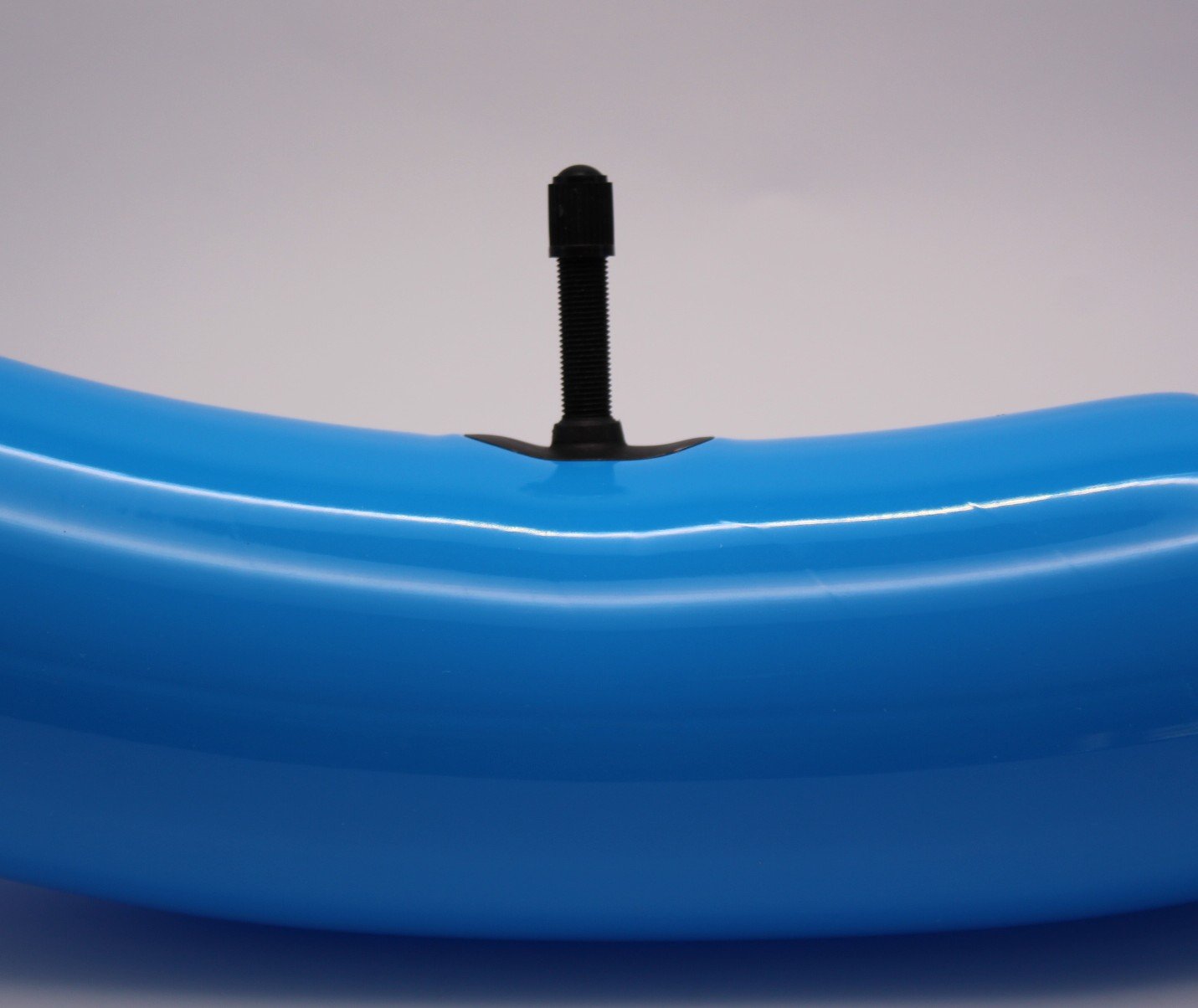 Close-up of a blue tube with a black valve on a gray background