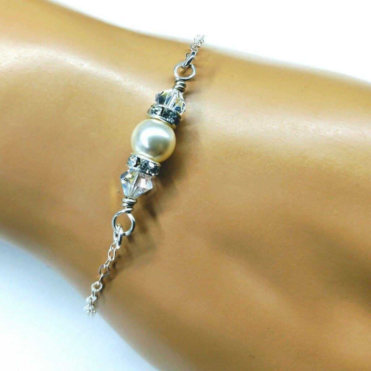 Pearl and crystal anklet on a person's ankle against a white background