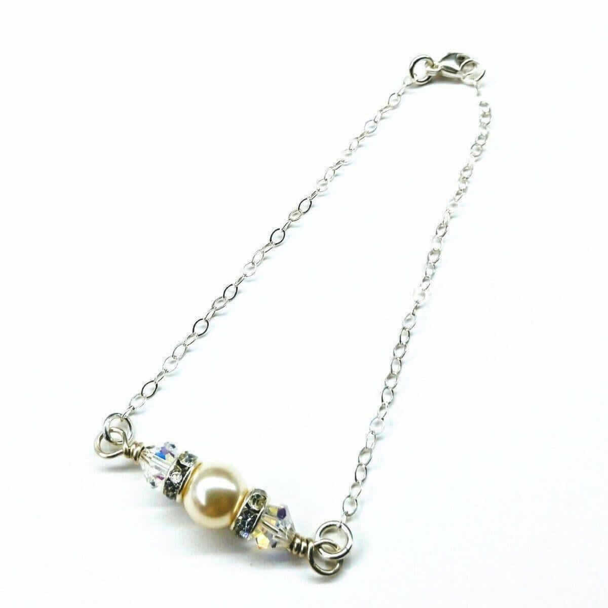 Silver bracelet with a pearl and crystal charm on a white background