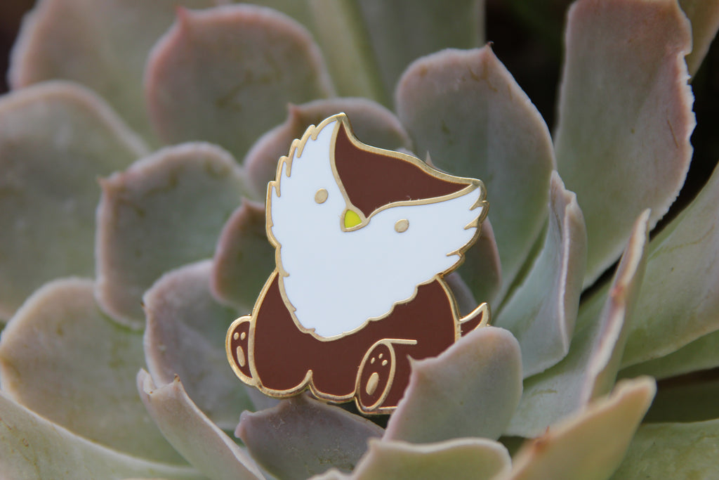 Enamel pin of a cartoon character on a succulent plant