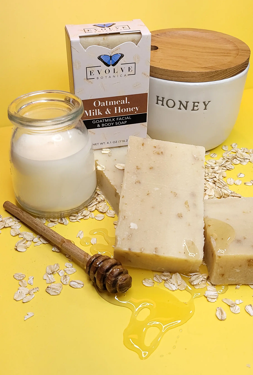 Oatmeal, Milk & Honey soap with jar of milk, honeycomb, and oats on a yellow background