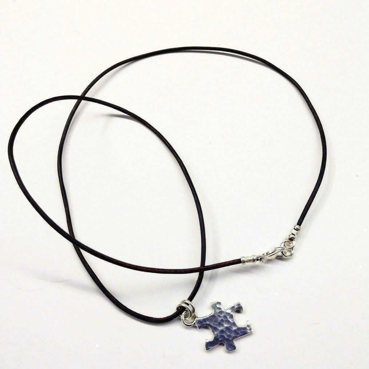 Necklace with a blue puzzle piece pendant on a white background