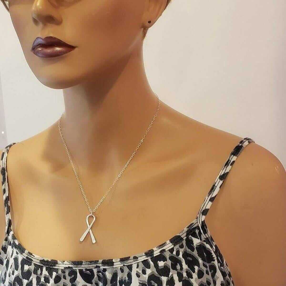 Mannequin wearing a leopard print top with a gold autism necklace.
