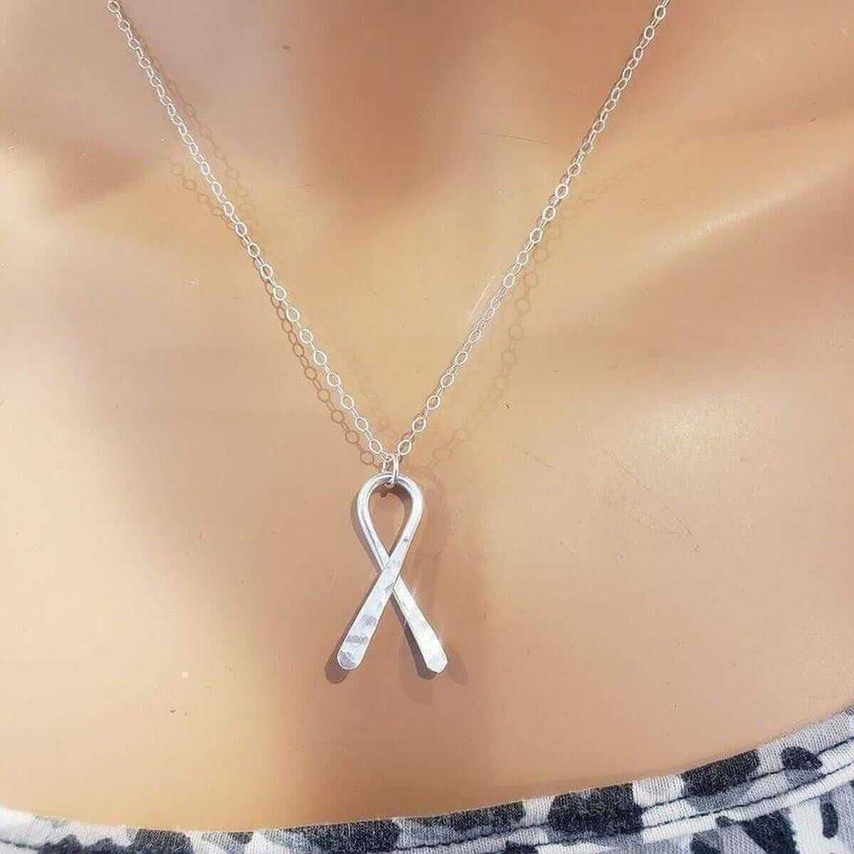 Silver autism ribbon pendant necklace on a person's neck