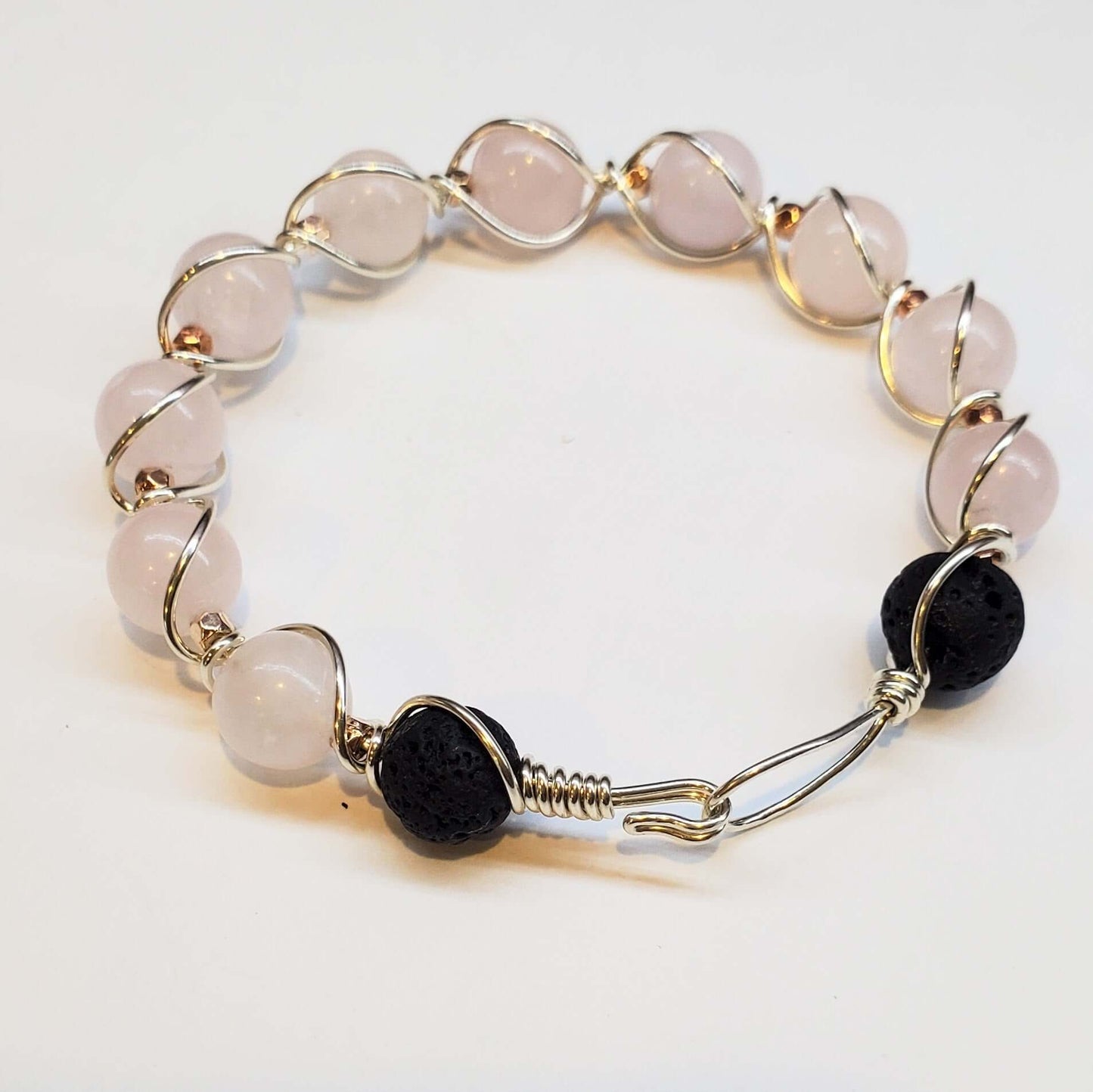 Bracelet with white beads and black stones on a white background
