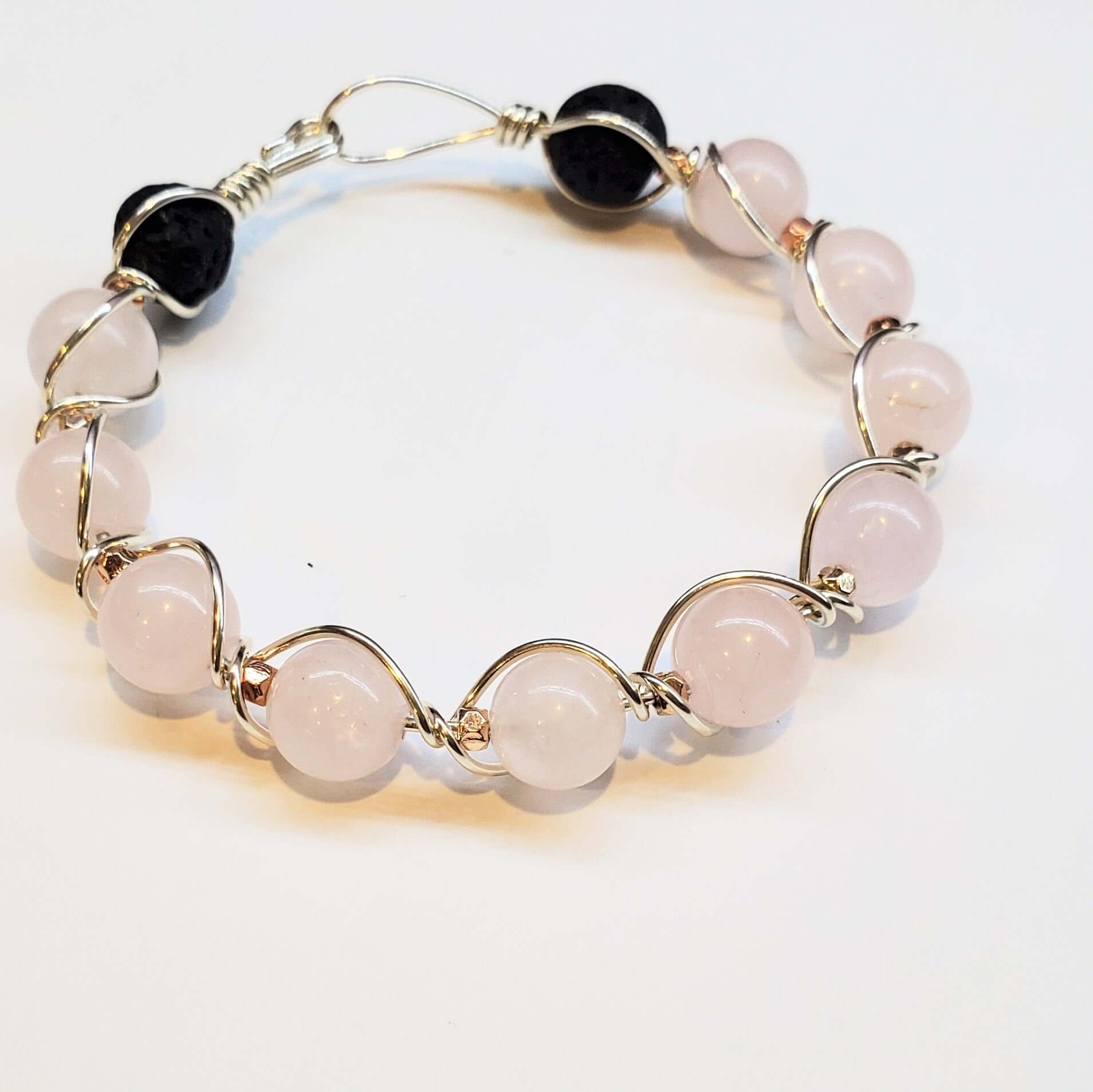 Bracelet with pink beads and gold accents on a white background