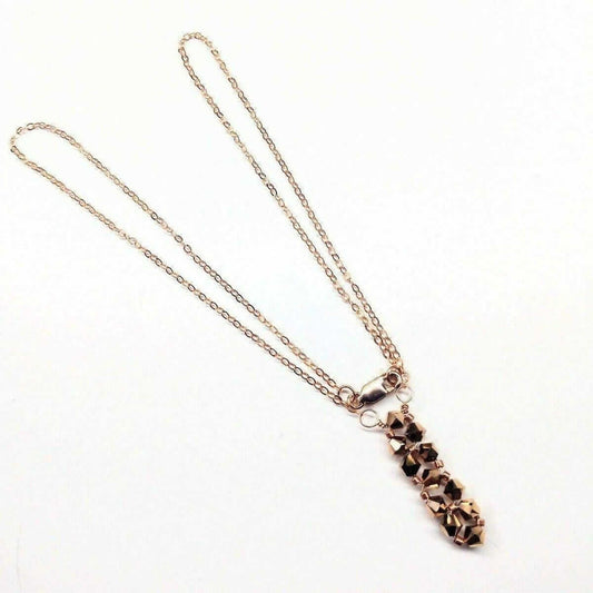 Necklace with a rose gold chain and pendant on a white background