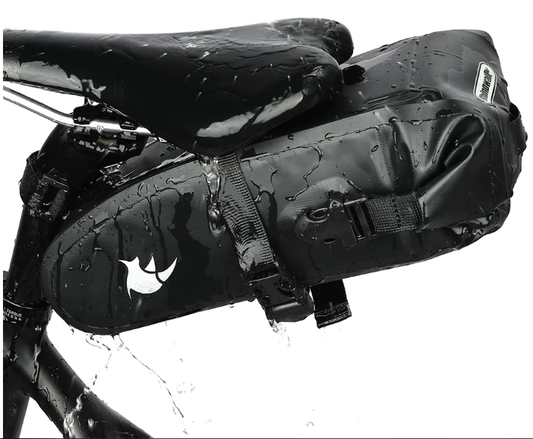 Black bike saddle bag attached to a bicycle with water droplets on a white background