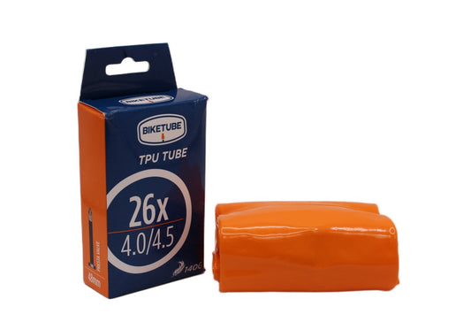 Orange bicycle tube and its packaging on a white background