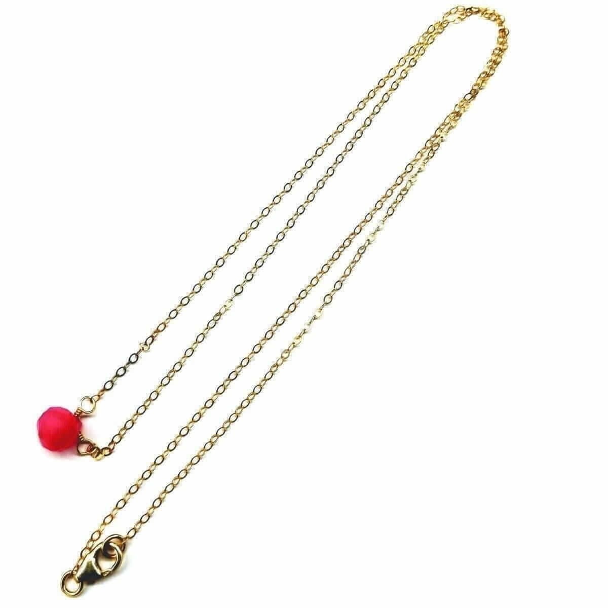 Gold chain necklace with a red pendant on a white background