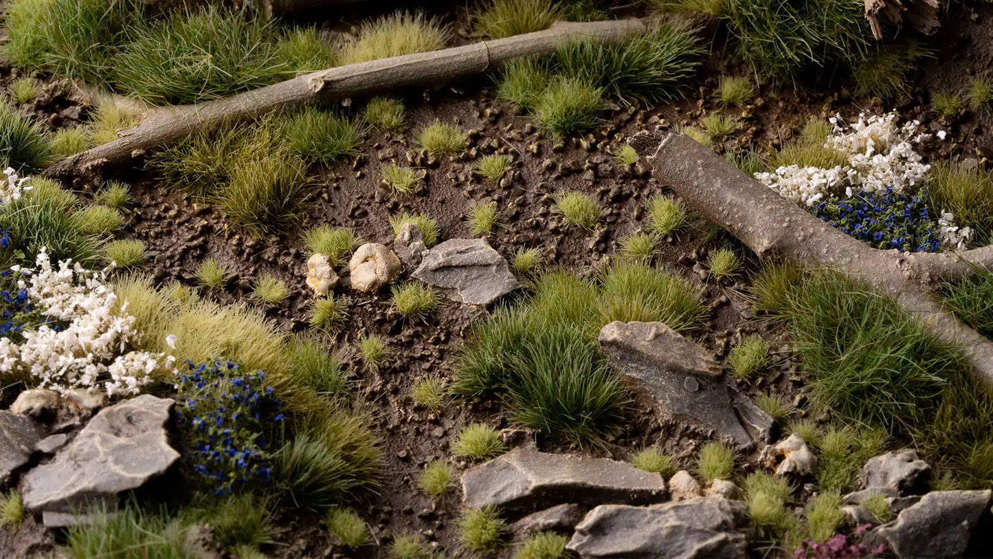 Miniature landscape with grass, rocks, and a log on a dark background