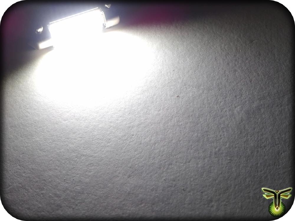 Light source on a textured white surface with a brand logo in the corner.