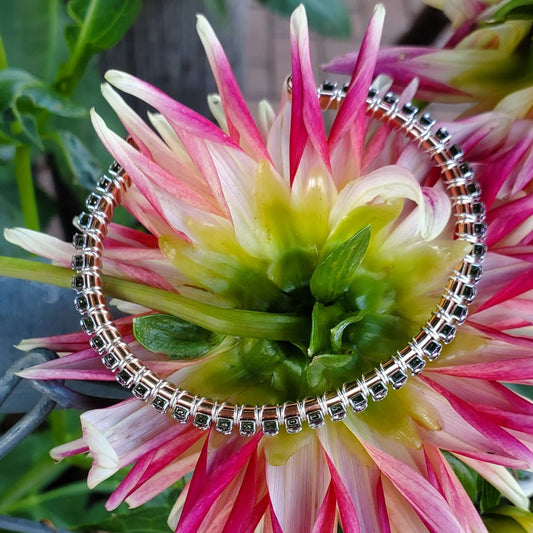 Silver bracelet with black stones on a pink and green flower