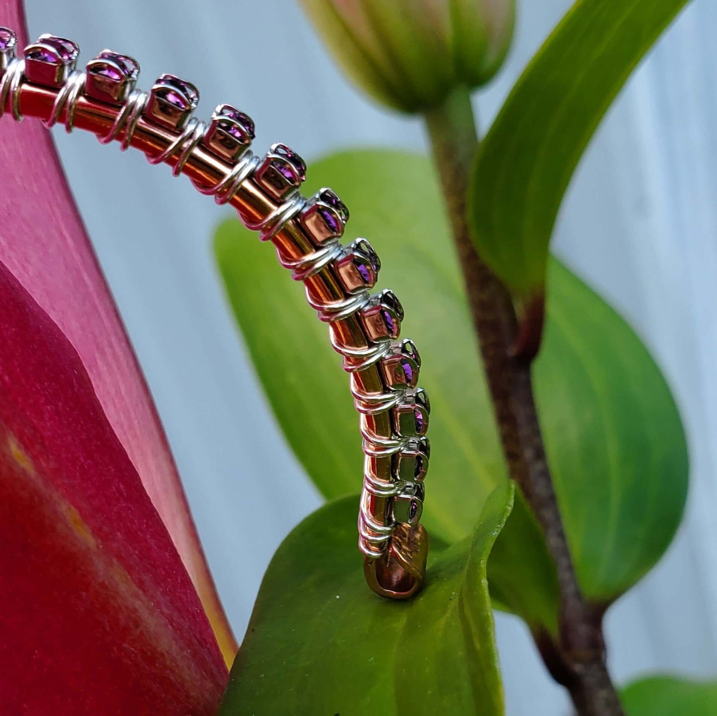 Metallic bracelet on a leaf with a blurred background