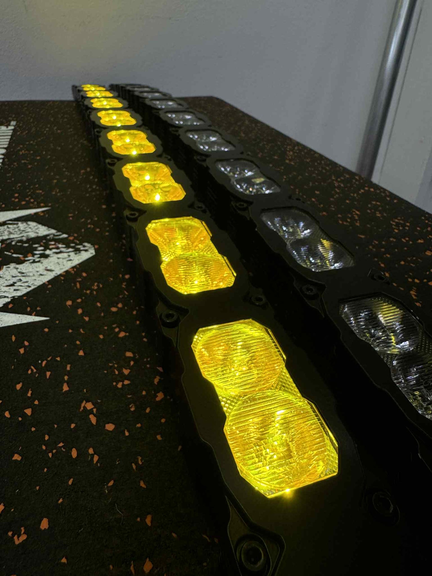 Row of yellow LED lights on a black surface with a white background