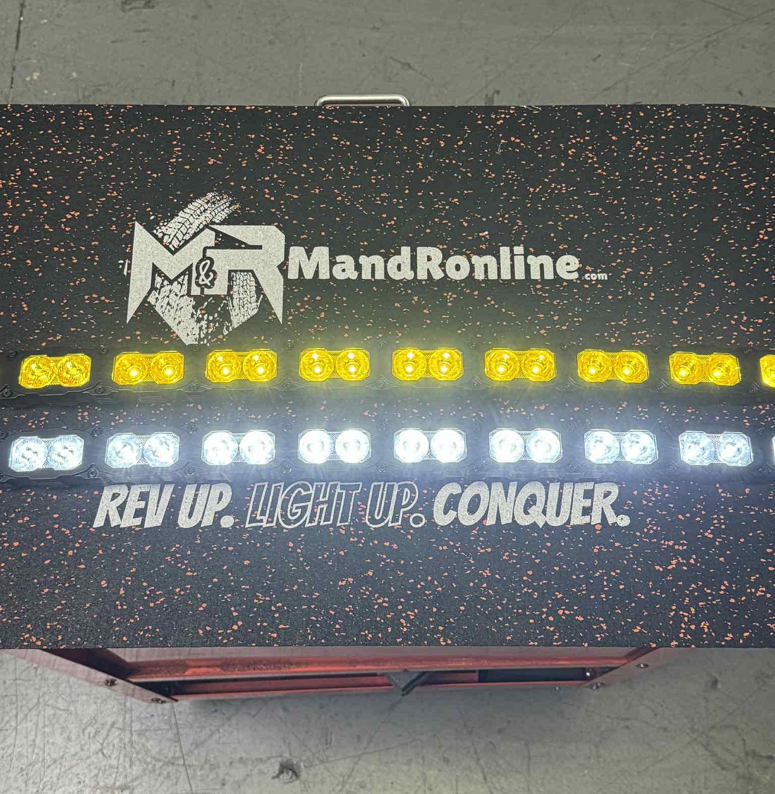 Light-up sign with 'MandRonline' logo and text on a dark background