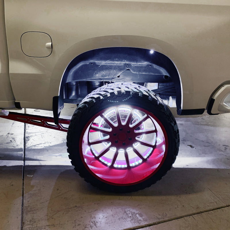 Car with a spare tire mounted on a stand, showing off its underbody lighting