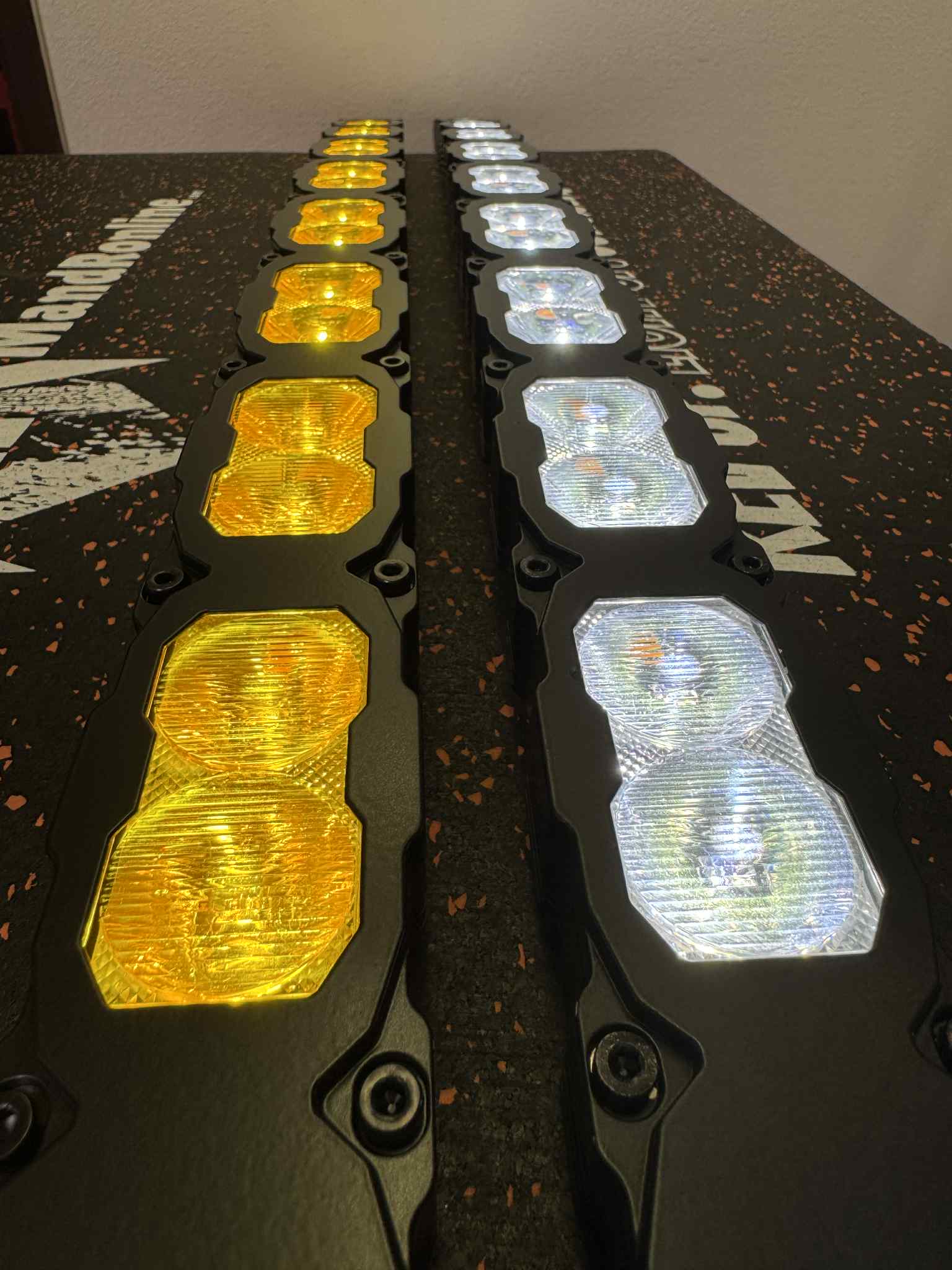 Two rows of LED lights, one yellow and one clear, on a black surface with branding.