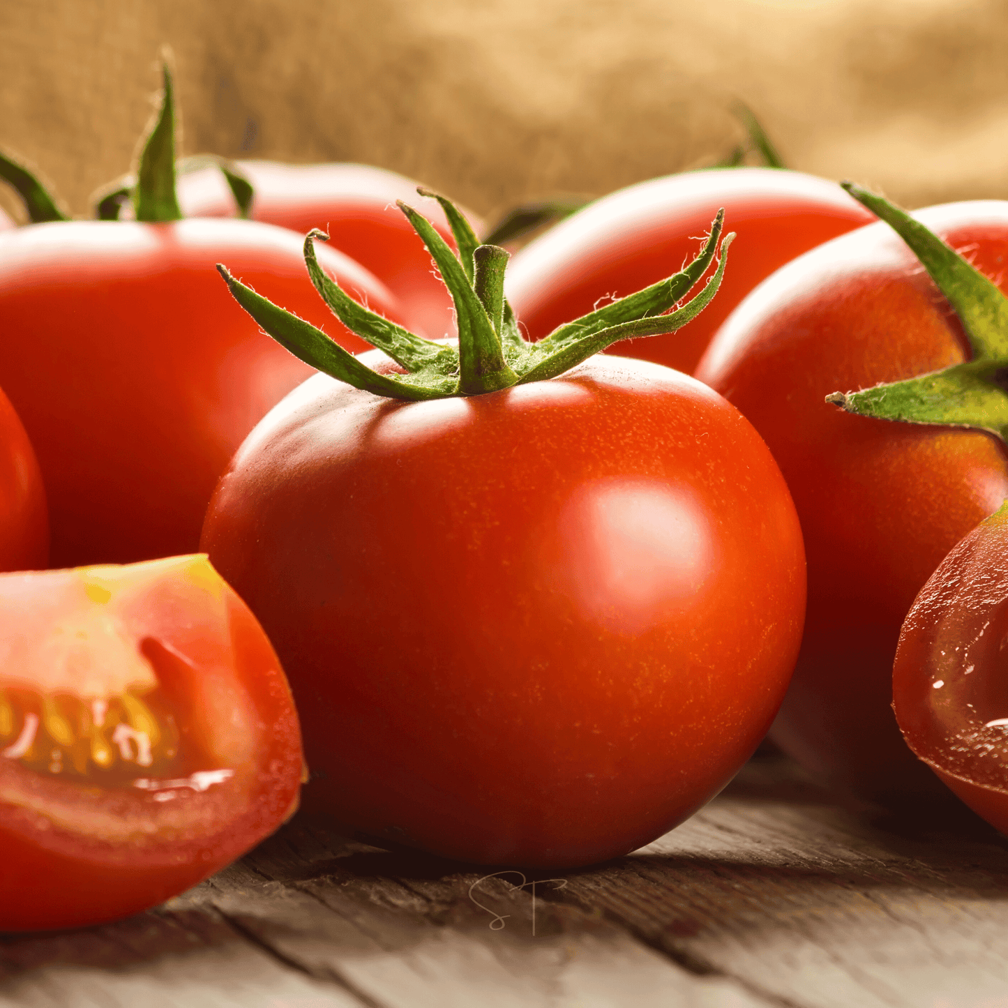 Fresh tomatoes with green stems on a rustic wooden surface