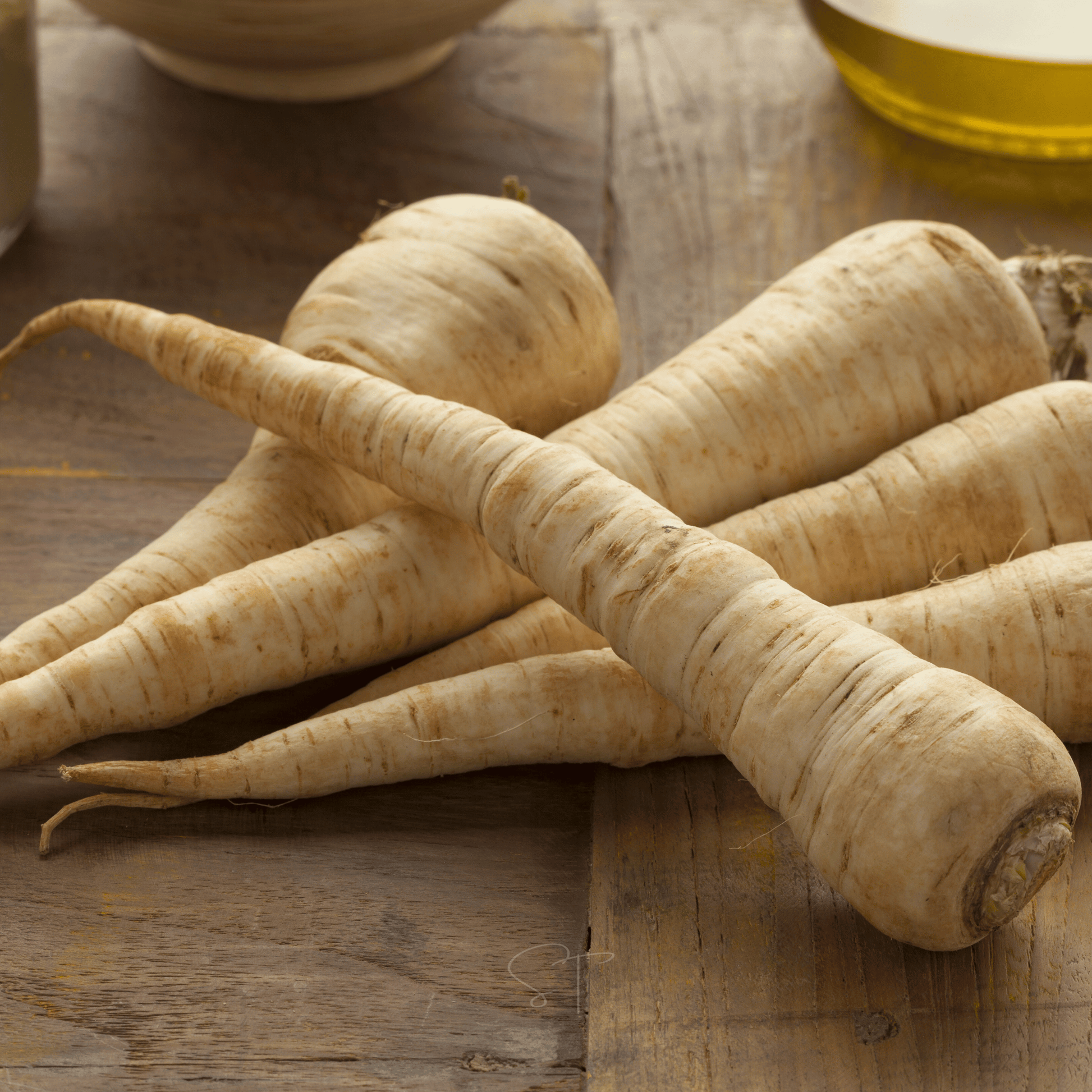  Parsnips on a wooden surface