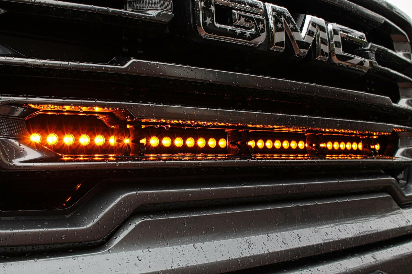 GMC vehicle grille with LED lights on a dark background