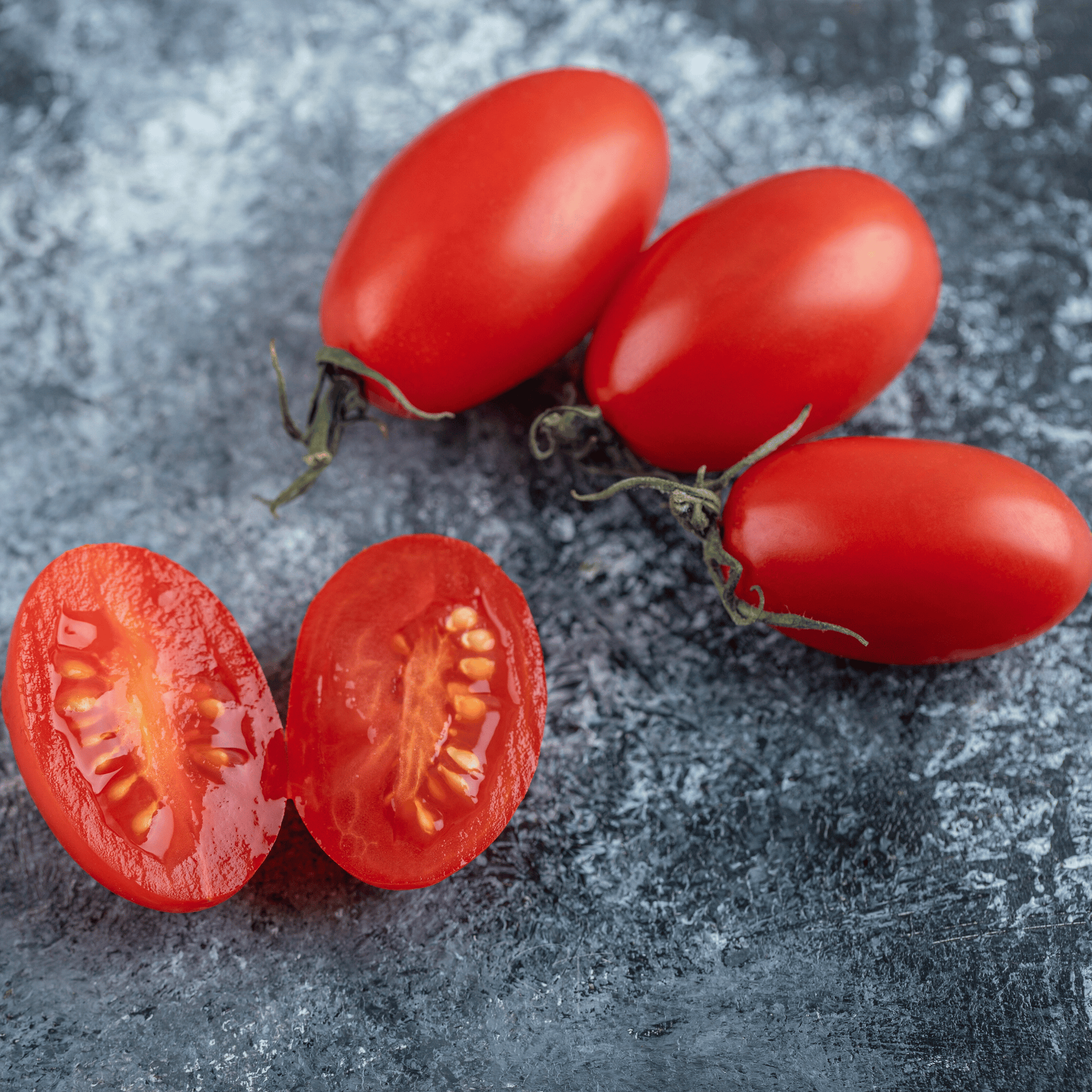 Red tomatoes on a textured gray surface