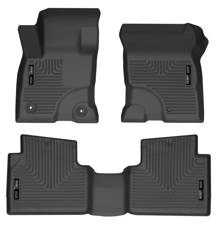 Set of four black car floor mats on a white background