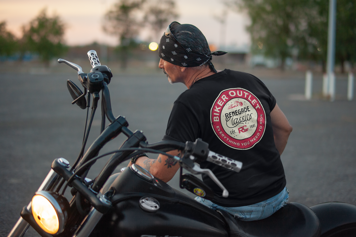 Biker wearing Black crew neck t-shirt with a round red and white 'Biker Outlet Renegade Classics' print on the  back sitting on his motorcycle