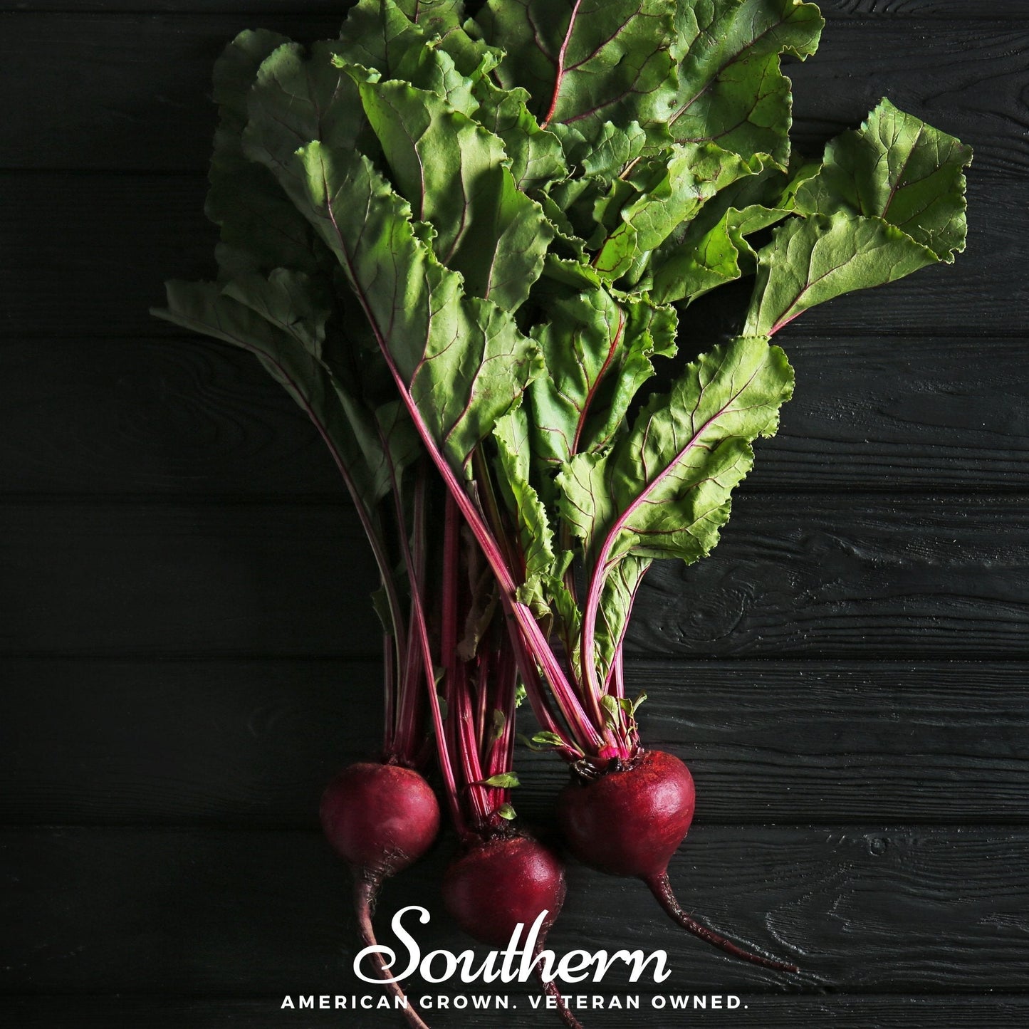 Bunch of beets with green leaves on a dark wooden background, featuring the brand 'Southern'.