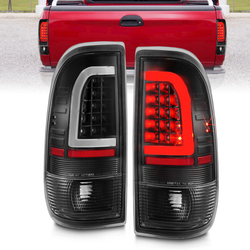 Pair of black and red tail lights with a red truck in the background.