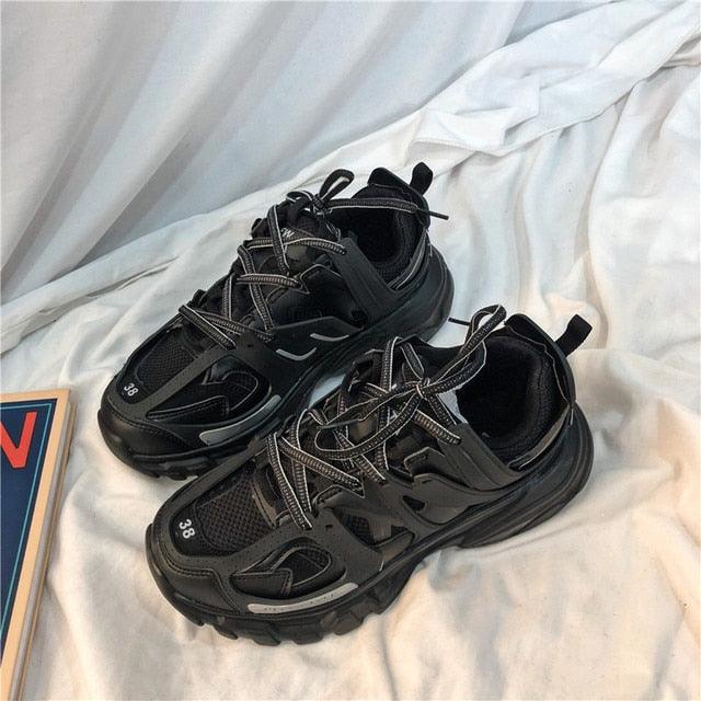 Pair of black sneakers on a light fabric background