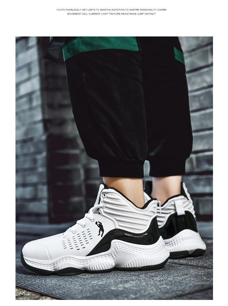 White and black sneakers worn with black pants against a brick wall.