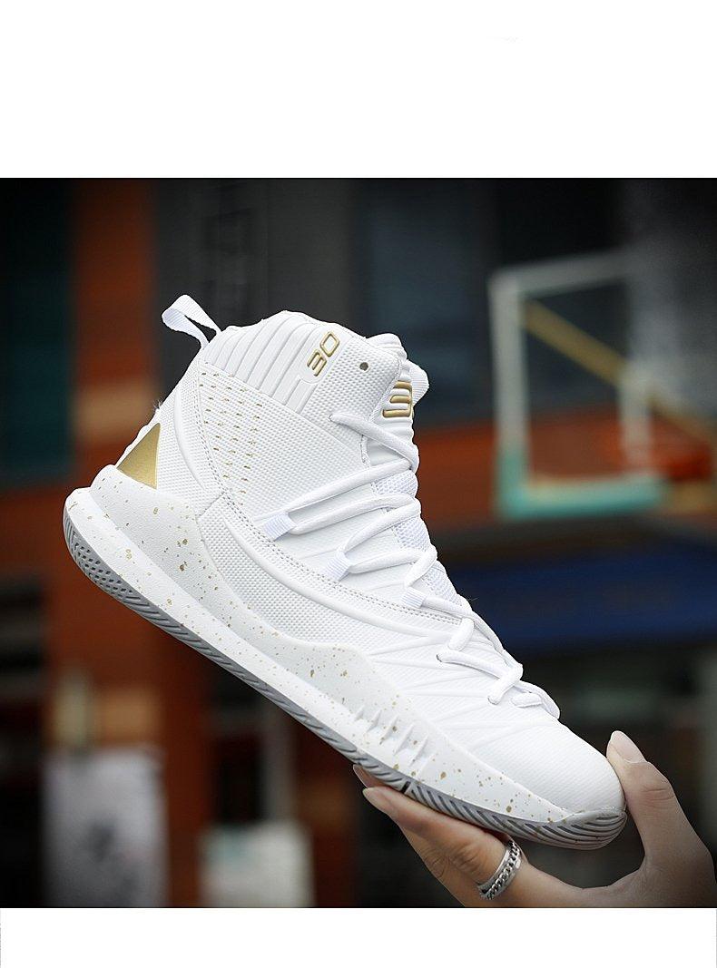 White high-top sneaker with gold accents held by a hand against a blurred indoor background