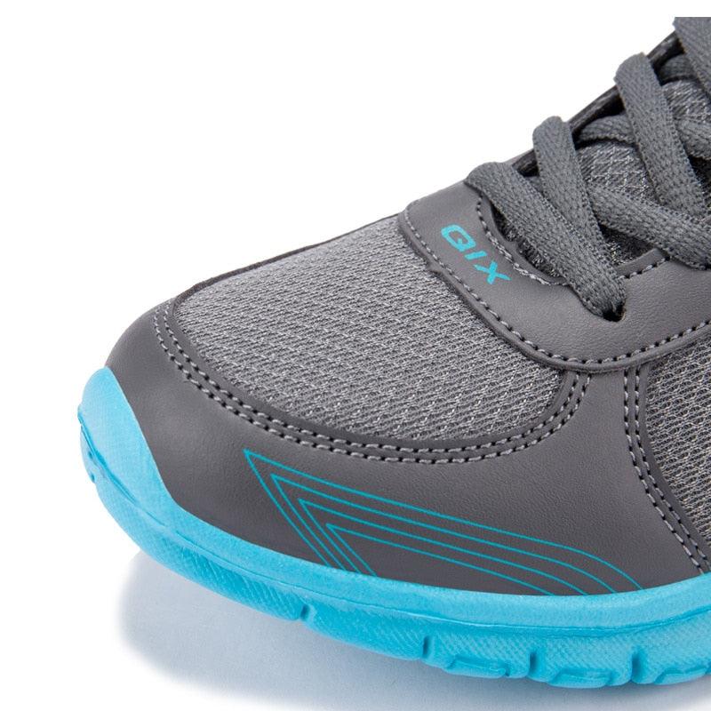 Gray athletic shoe with blue sole on a white background