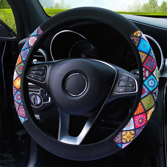 Steering wheel with a colorful patterned cover inside a car.