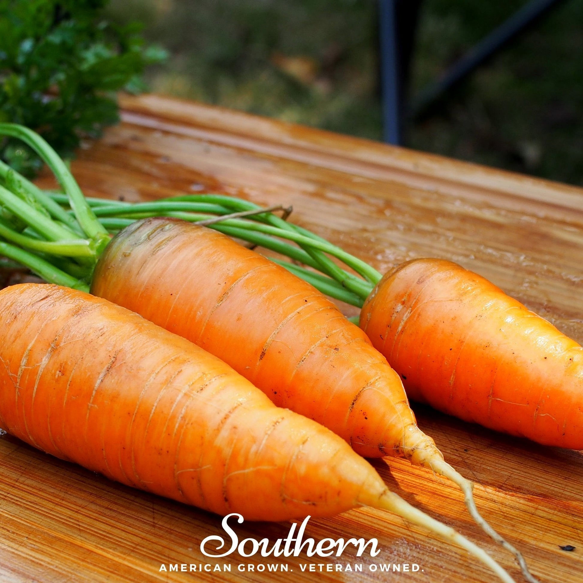 Three fresh carrots on a wooden surface with 'Southern' branding.