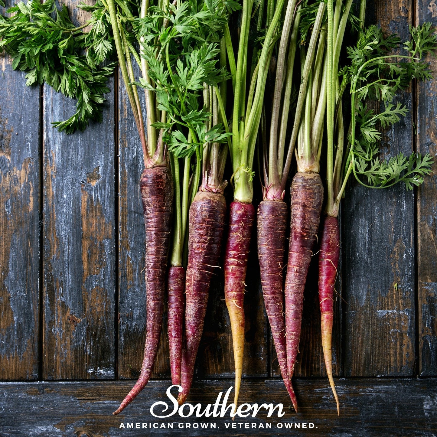 Purple carrots with green tops on a wooden background, featuring the 'Southern' brand.