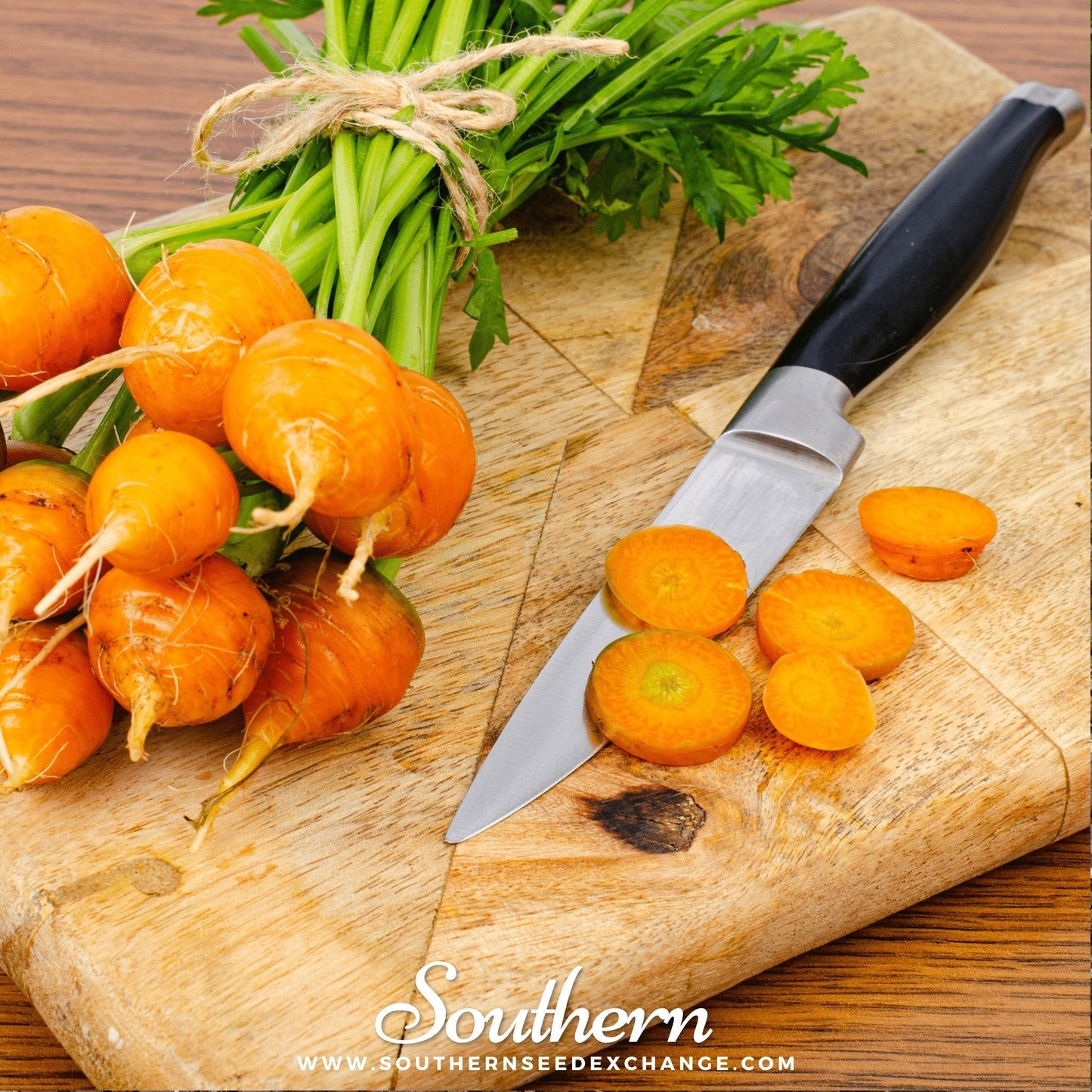 Carrots on a wooden cutting board with a knife, branded 'Southern Seed Exchange'.