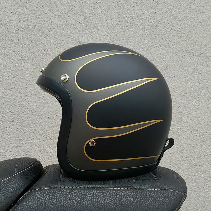 Black motorcycle helmet with gold accents on a gray surface