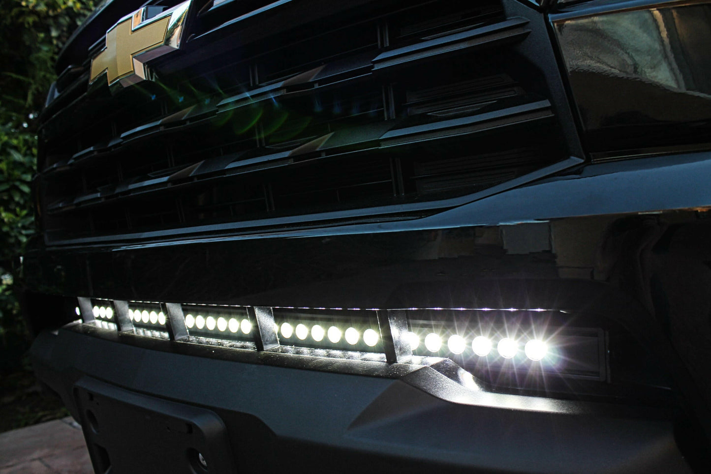 Close-up of a Chevrolet vehicle's front grille with LED lights on.
