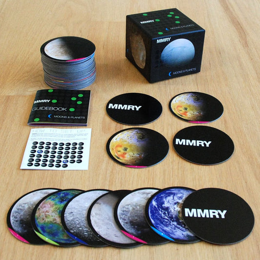 MMRY lunar and planetary themed products including coasters and a guidebook on a wooden surface.