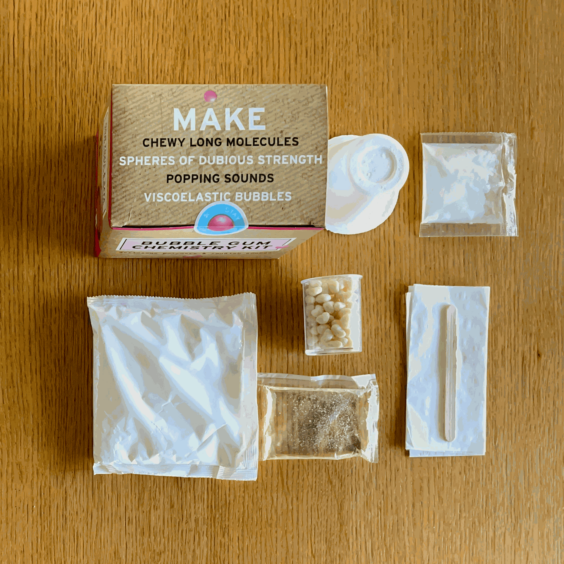 Bubble Gum Chemistry Kit components on a wooden surface