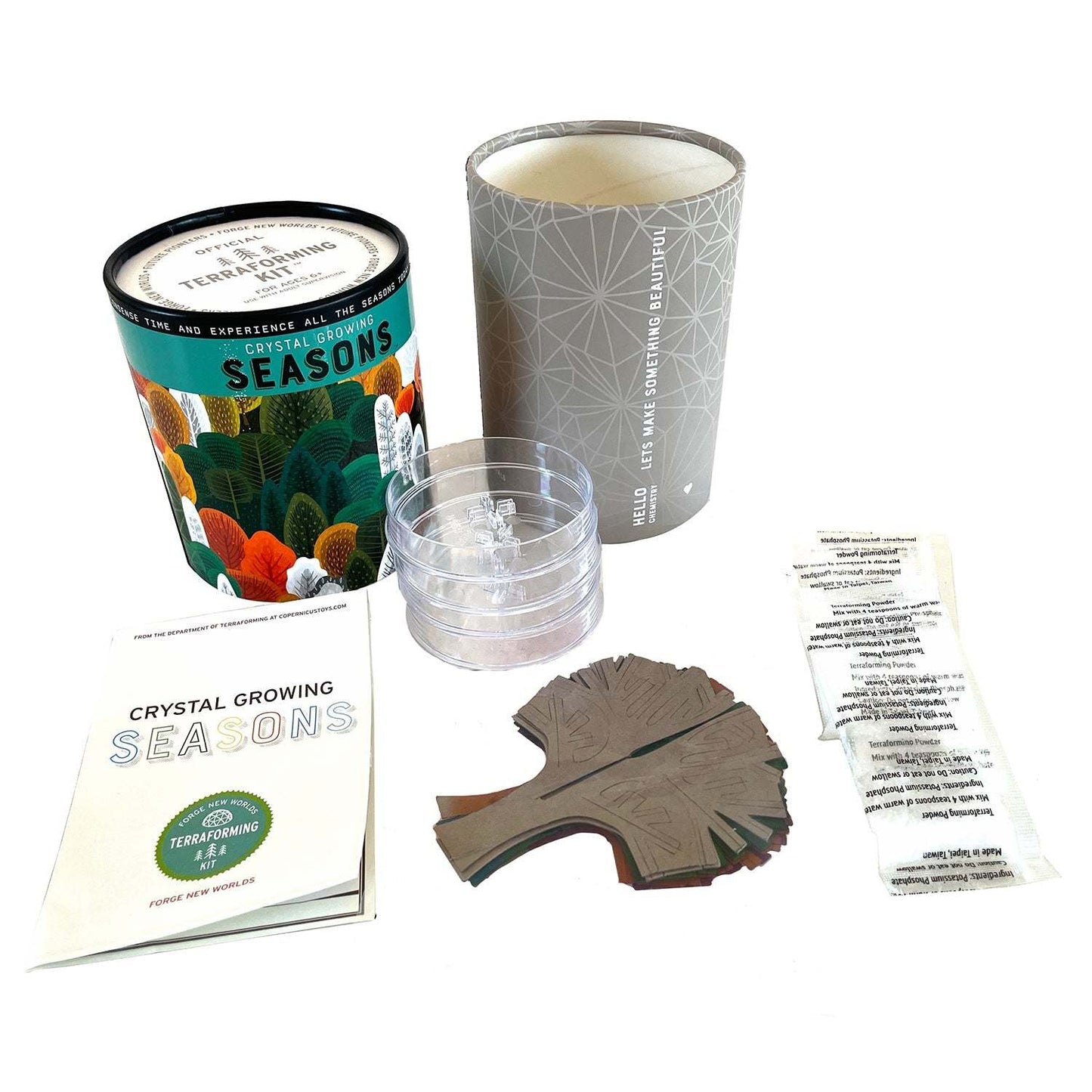 Crystal growing kit with containers, crystal, and instructions on a white background