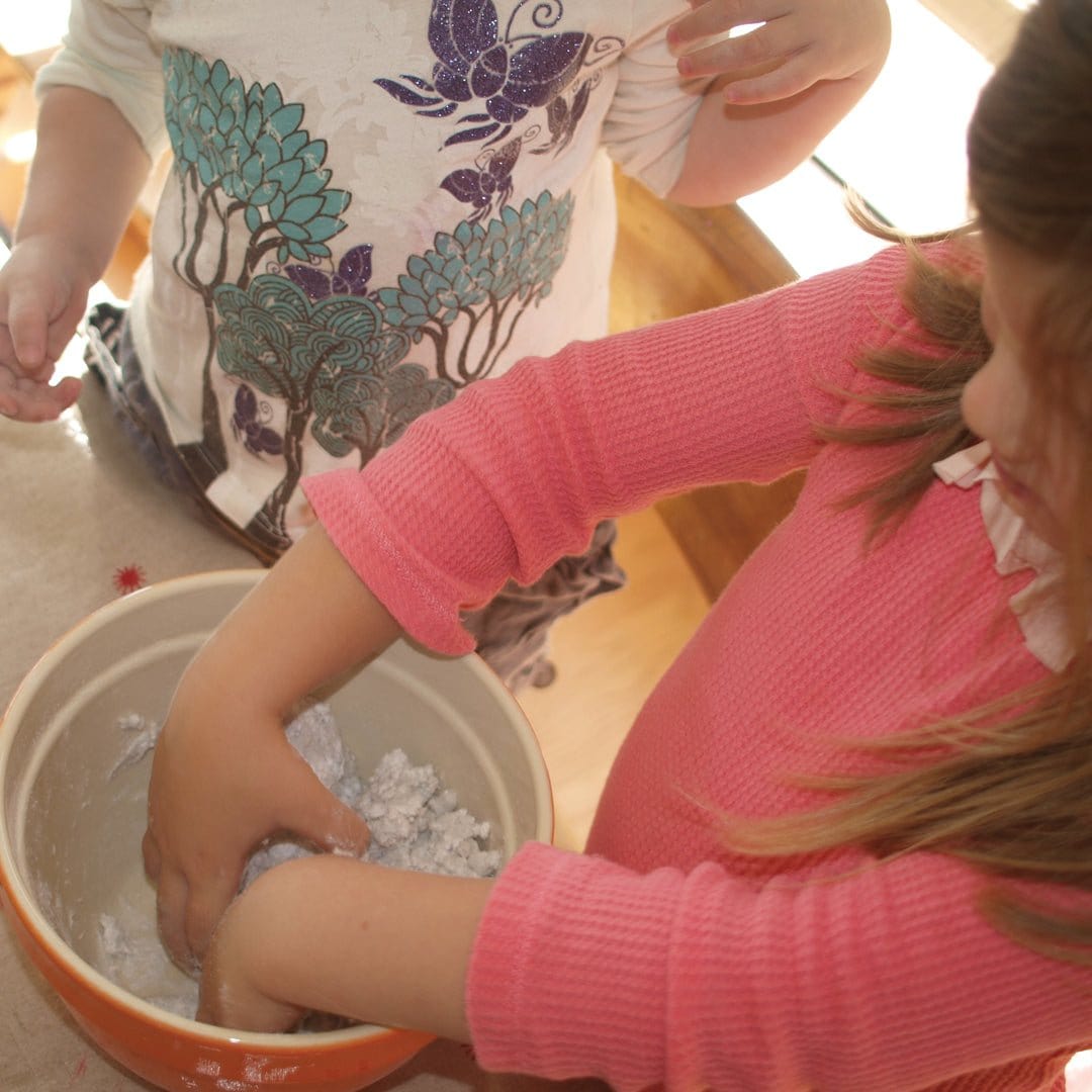 Child in pink sweater making a volcano from the kit