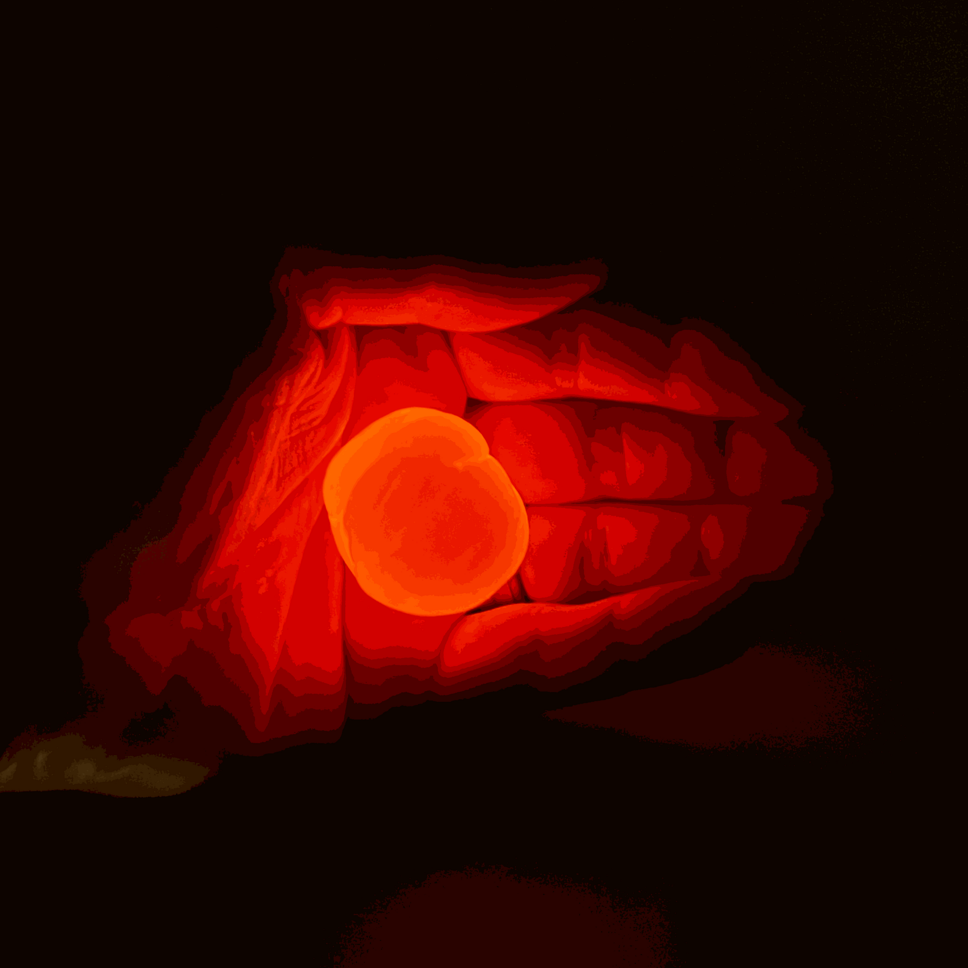 Hand holding a glowing orange sphere against a black background