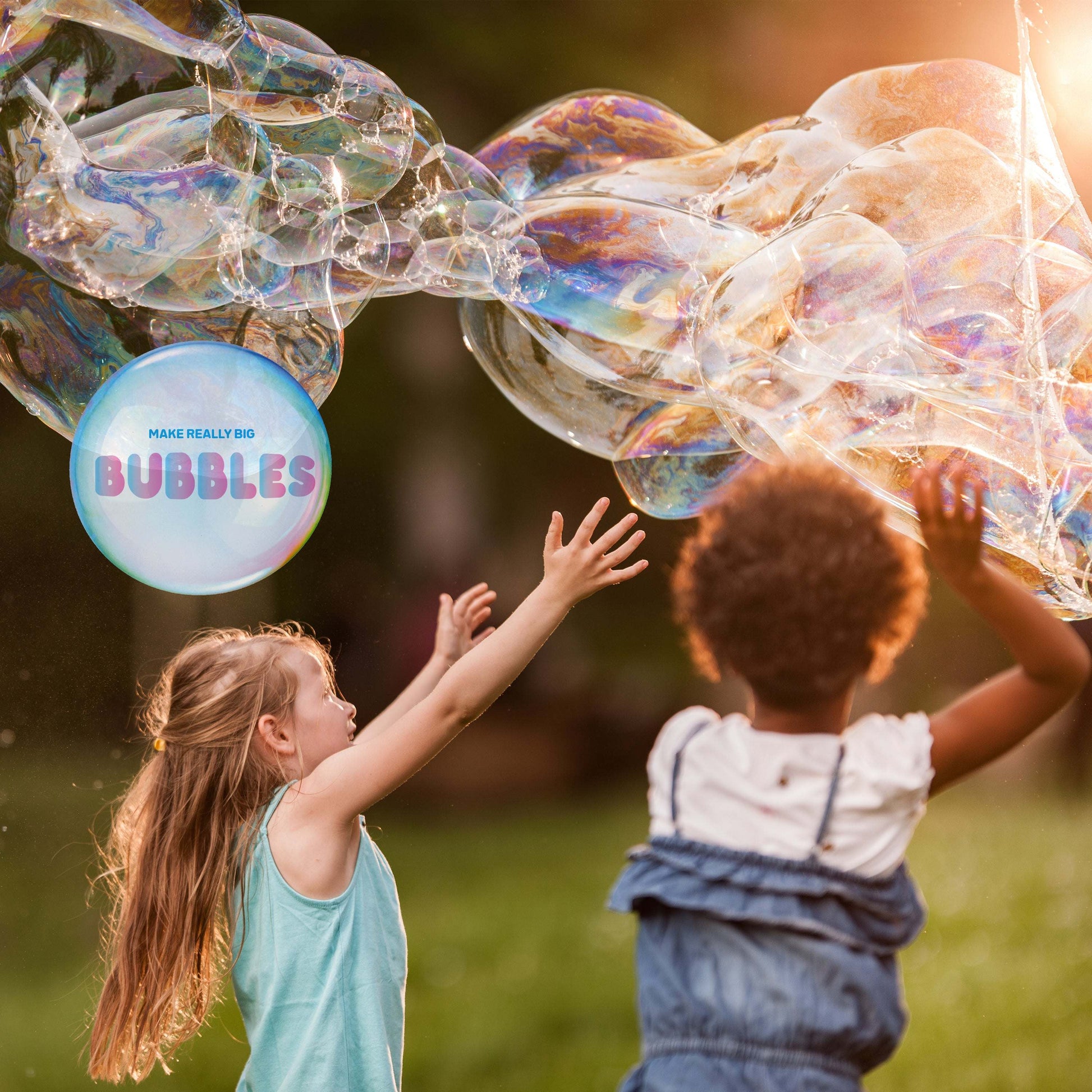 Two children playing with large bubbles outdoors, with a bubble wand labeled 'MAKE REALLY BIG BUBBLES'.