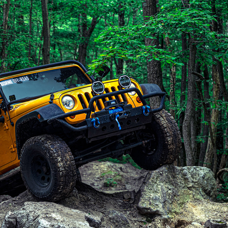 Yellow off-road vehicle navigating rocky terrain in a forest