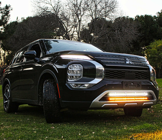 Black SUV with LED Light Bars parked on grass with trees in the background