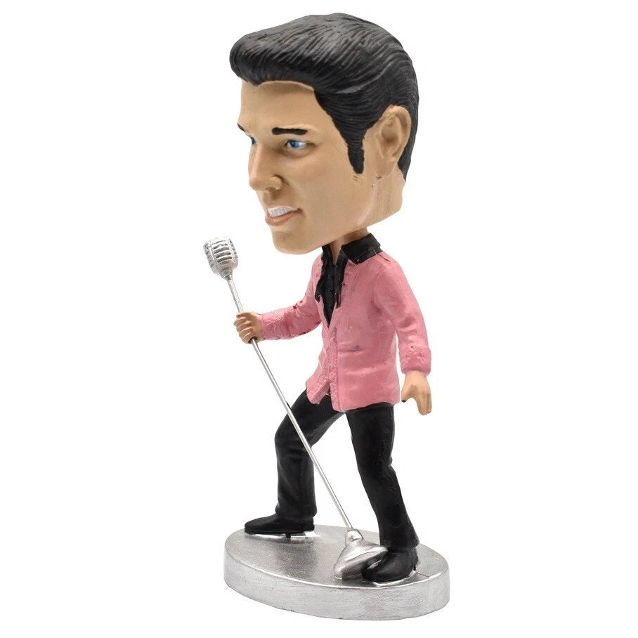 Bobblehead figure of Elvis in a pink shirt holding a microphone on a white background